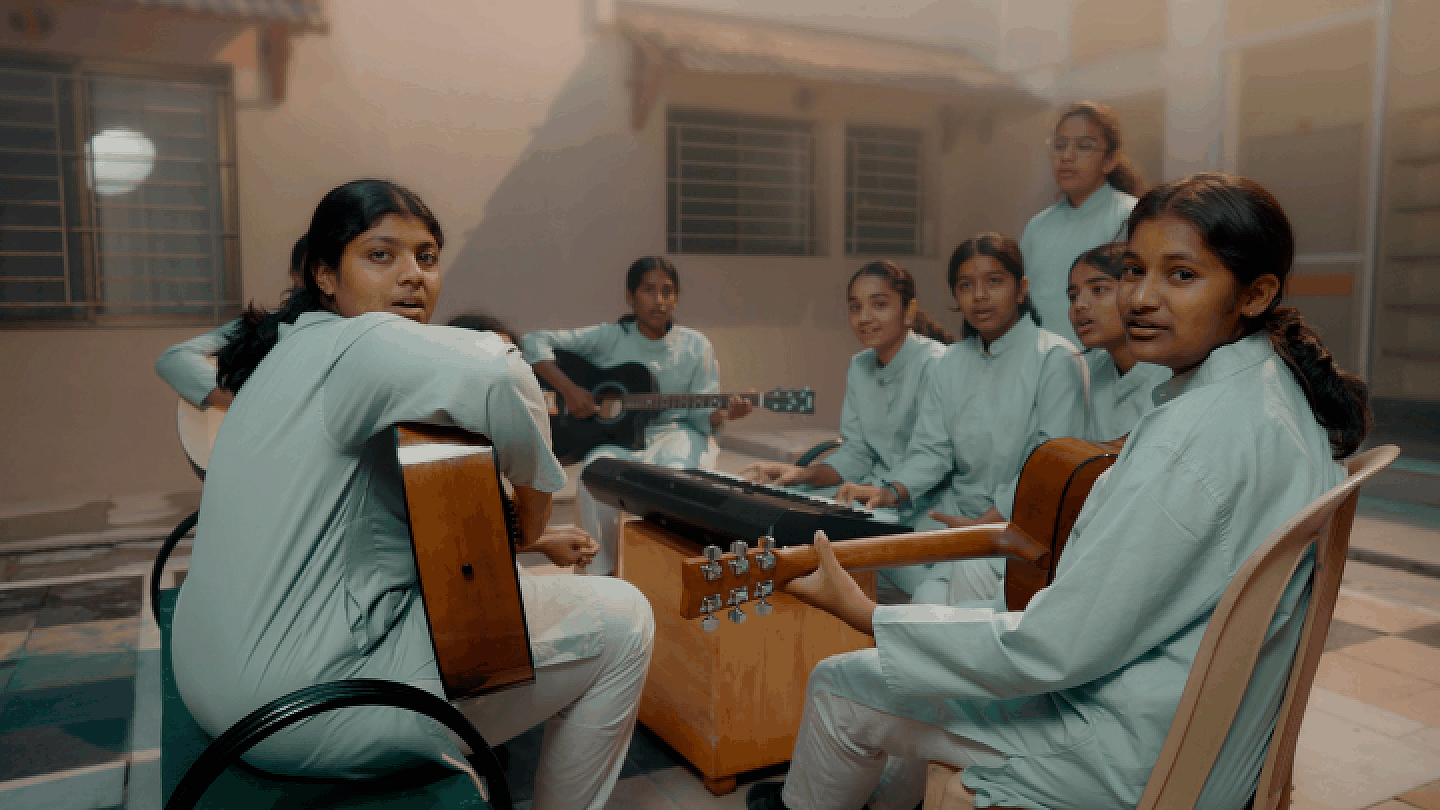 Students playing music and relaxing together in the dorm courtyard